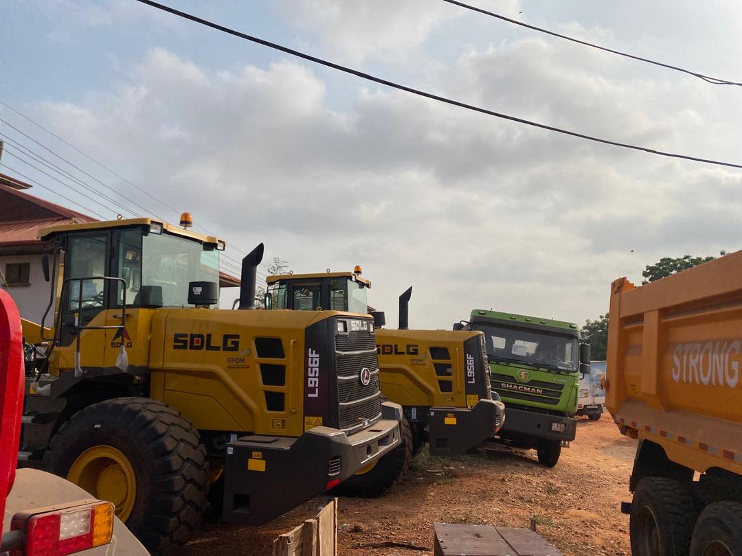 Ongoing installation — SDLG wheel loaders and SHACMAN trucks at a job site